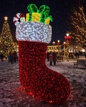 Giant illuminated Christmas stocking in snowy town square