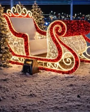 Illuminated Christmas sleigh decoration in snowy night setting